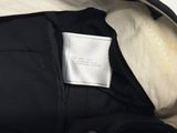 the label on the back of a black jacket is clearly visible