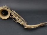 an old saxophone is laying on a black surface