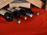several bottles of wine are lined up on a red table cloth