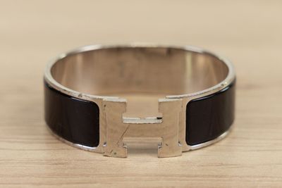 black and silver bracelet with a letter h in the middle