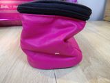 a pink purse sitting on a table with a pink purse in the background