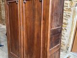 une grande armoire en bois surmontée d'une porte