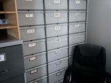 a desk with a chair in front of a filing cabinet