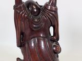 an image of a wooden statue of a man with his hands in the air