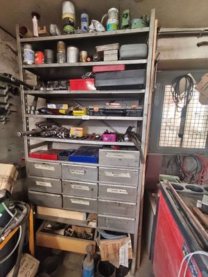 un garage encombré, avec des outils empilés sur les étagères