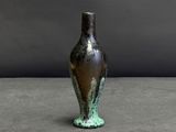 un vase posé sur une table à fond gris