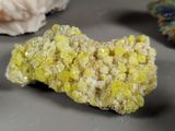 a piece of rock with yellow crystals on top of it