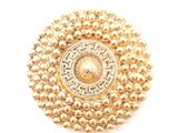 un gros plan d'une broche en or ornée de perles