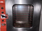 a red oven sitting on a black table in a room