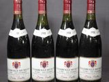 quatre bouteilles de vin sont alignées sur une table