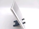 a tablet computer sitting on a stand on a white surface