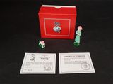 une boîte rouge sur laquelle sont posées deux petites figurines