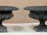 deux vases noirs posés sur une table blanche