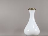 une paire de vases blancs et dorés posés sur une table, à côté d'une petite lampe