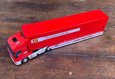 un camion rouge posé sur un plancher en bois