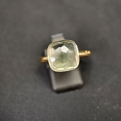 une bague sertie d'une pierre verte, posée sur une table