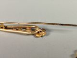 a close up of a gold pin with a flower on it