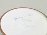 a white bowl with writing on it sitting on a table