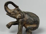 statue représentant un éléphant debout sur ses pattes arrière, la trompe levée