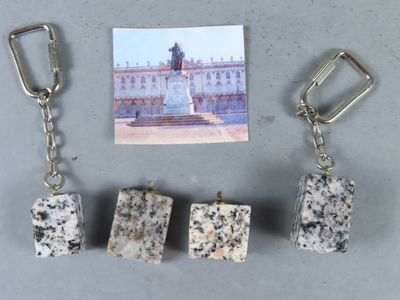 trois morceaux de pierre sur un porte-clés, à côté de la photo d'un bâtiment
