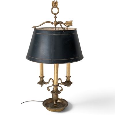 une lampe de table en laiton ancien avec un abat-jour noir sur fond blanc