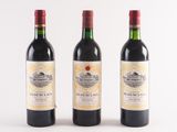three bottles of wine are lined up on a white surface