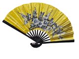 an image of a yellow and black fan with flowers on it