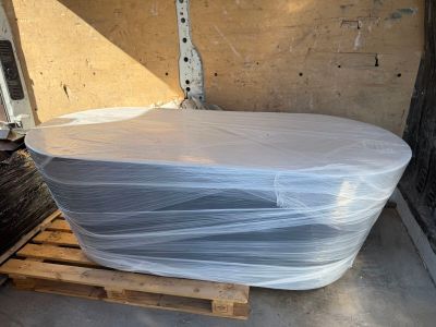 a large white tub sitting on a pallet in the back of a truck