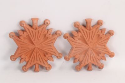 une paire de flocons de neige en céramique orange sur un fond blanc