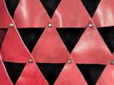 a close up of a red and black leather belt with metal rivets