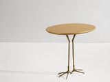 une image représentant une table dorée à deux pieds et dotée d'un plateau rond