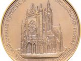 a gold medal with a picture of a cathedral on it