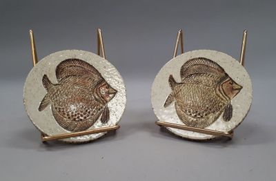 pair of gold and white ceramic fish bookends on stands