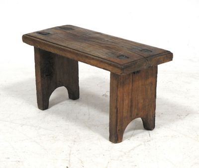 a small wooden bench sitting on a white surface