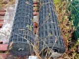 two rolls of wire on a pallet in the grass