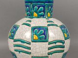 un vase blanc orné de motifs bleus et jaunes