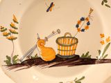 a plate with a painting of a snail and a bucket on it