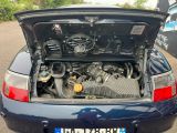 a blue car with a engine in the trunk of it