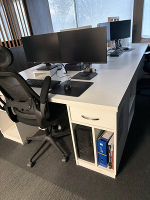 un bureau avec deux écrans d'ordinateur et une chaise placée devant