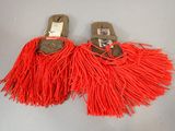 pair of sandals with red tassels on a gray surface