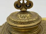 an antique brass inkwell with a lid on a white background