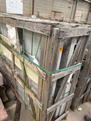 a pile of old windows in the back of a building