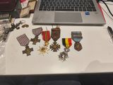 un ordinateur portable posé sur un bureau sur lequel sont disposées des médailles