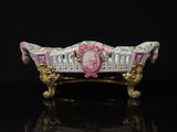 une baignoire rose et dorée sur laquelle est représentée une femme