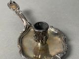 a silver plate with a candle holder on top of it