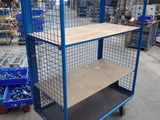 a blue cart with a shelf in the middle of a warehouse