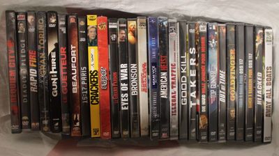 beaucoup de DVD dans un sac en plastique posé sur une table