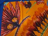 a colorful scarf with a picture of a dragonfly and flowers on it