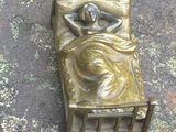 statue représentant une femme allongée dans un lit posé sur une surface sale