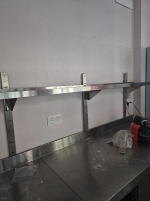a kitchen with a stainless steel counter top and a refrigerator